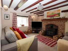 A living room with a fireplace and sofa at Clara's Cottage in West Lutton near Malton