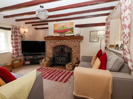 A living room with a fireplace and TV at Clara's Cottage West Lutton near Malton