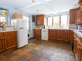 A kitchen with wooden cabinets and a fridge at Clara's Cottage West Lutton near Malton