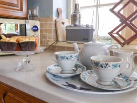 A kitchen with tea set and baked goods at Clara's Cottage in West Lutton near Malton