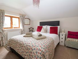 A bedroom with a bed and decorative pillows at Clara's Cottage in West Lutton near Malton