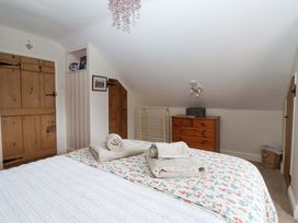 A bedroom with a bed and dresser at Clara's Cottage in West Lutton near Malton