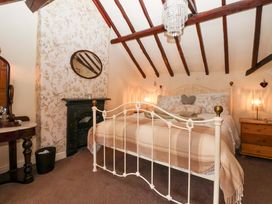 A bedroom with a bed, mirror, and chest of drawers at Clara's Cottage in West Lutton near Malton