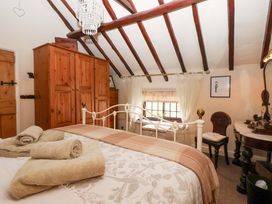 A bedroom with a bed and wardrobe at Clara's Cottage West Lutton near Malton