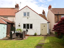 A cottage with a seating area in the garden at Clara's Cottage West Lutton near Malton