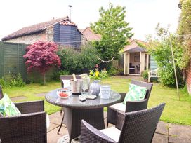 A garden with a table, chairs, and shed at Clara's Cottage in West Lutton near Malton