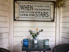 A outdoor seating area with cups and a flower vase at Clara's Cottage in West Lutton near Malton