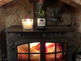 A candle and wine bottle on a wood stove at Clara's Cottage West Lutton near Malton