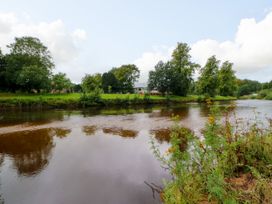 A river with trees and a building in the background at 27 Bongate Appleby-In-Westmorland