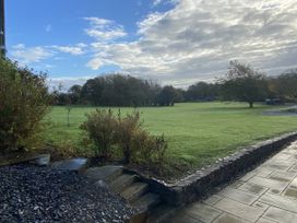 An outdoor view of a grassy area with trees and a pathway at The Shippons in Abersoch