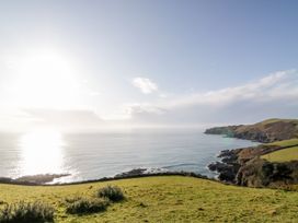 A coastal view with hills and ocean at Tinners Cottage in Liskeard
