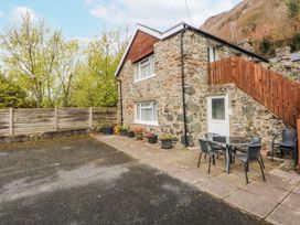 An outdoor area with a stone building and seating at Ground Floor Apartment, Tremadog