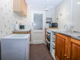 A kitchen with appliances and cabinetry at Ground Floor Apartment Tremadog