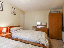 A bedroom with two beds and a wardrobe at Ground Floor Apartment Tremadog