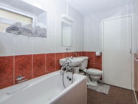 A bathroom with a bathtub, toilet, and sink at Ground Floor Apartment in Tremadog