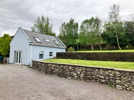 A house with a stone wall and grassy area at Silver Birch House Beaufort Killarney County Kerry