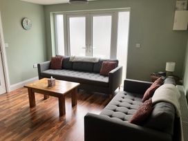 A living room with two sofas and a wooden table at Silver Birch House Beaufort Killarney County Kerry