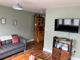 A living room with a sofa and television at Silver Birch House, Beaufort Killarney, County Kerry