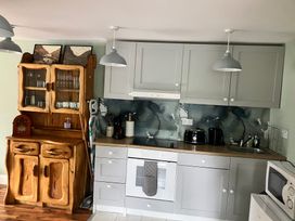 A kitchen with wooden cabinet and appliances at Silver Birch House Beaufort Killarney County Kerry