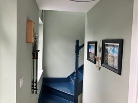 A staircase with wall hooks and pictures in the hallway at Silver Birch House, Beaufort Killarney, County Kerry