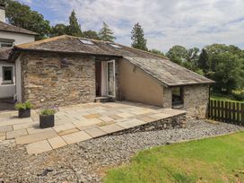 An outdoor area with a stone wall and patio at Acorn in Bowness-on-Windermere