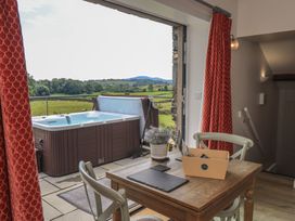 A seating area with a hot tub and view of the landscape at Acorn in Bowness-on-Windermere