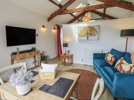 A living room with a television and sofa at Acorn in Bowness-on-Windermere