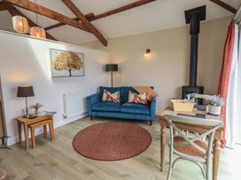 A living room with a blue sofa and wooden table at Acorn in Bowness-on-Windermere
