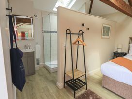 A bedroom with a shower and a mirror at Acorn in Bowness-on-Windermere