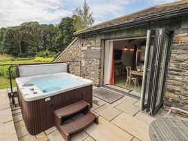 An outdoor area with a hot tub and patio at Acorn in Bowness-on-Windermere