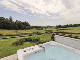 A hot tub overlooking a green field at Acorn in Bowness-on-Windermere