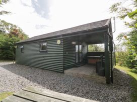 A cabin with a deck and gravel area at Ash Lodge in Pennington near Ulverston