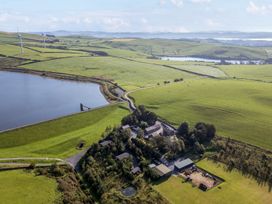 An aerial view of fields and buildings near a water body at Ash Lodge in Pennington near Ulverston