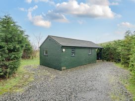 A green cabin surrounded by trees at Ash Lodge in Pennington near Ulverston