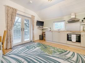 A kitchen with cabinets and a television at Ash Lodge in Pennington near Ulverston