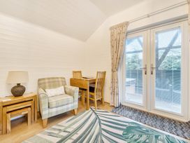 A living room with a chair and table at Ash Lodge Pennington near Ulverston