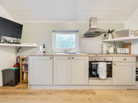 A kitchen with cabinets, sink, oven and television at Ash Lodge in Pennington near Ulverston