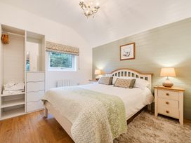 A bedroom with a bed and a wardrobe at Ash Lodge in Pennington near Ulverston
