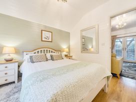 A bedroom with a bed and nightstand at Ash Lodge in Pennington near Ulverston