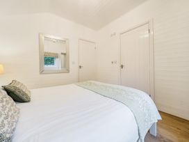 A bedroom with a bed and a mirror at Ash Lodge Pennington near Ulverston