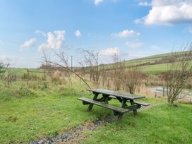 A picnic table in a grassy area near a stream at Ash Lodge in Pennington near Ulverston