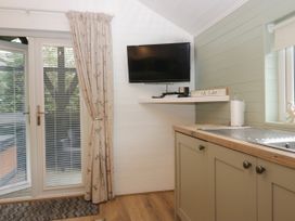 A kitchen with a window and television at Ash Lodge Pennington near Ulverston
