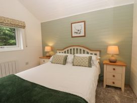 A bedroom with a bed and nightstands at Ash Lodge Pennington near Ulverston