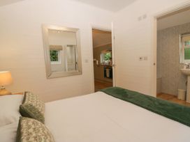 A bedroom with a bed and a mirror at Ash Lodge in Pennington near Ulverston