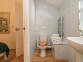 A bathroom with a toilet, sink, towels and a mirror at Ash Lodge, Pennington near Ulverston