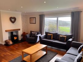 A living room with a fireplace and furniture at Rhos Helyg in Penysarn near Amlwch