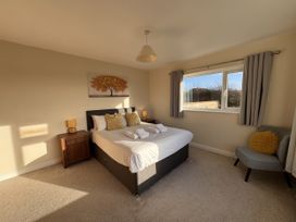 A bedroom with a bed and window at Rhos Helyg Penysarn near Amlwch