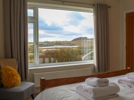 A bedroom with a window view at Rhos Helyg in Penysarn near Amlwch