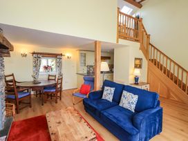 A living room with a sofa and dining area at Pheasant Cottage Beckside near Cartmel