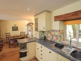 A kitchen with a sink and cabinets at Pheasant Cottage Beckside near Cartmel